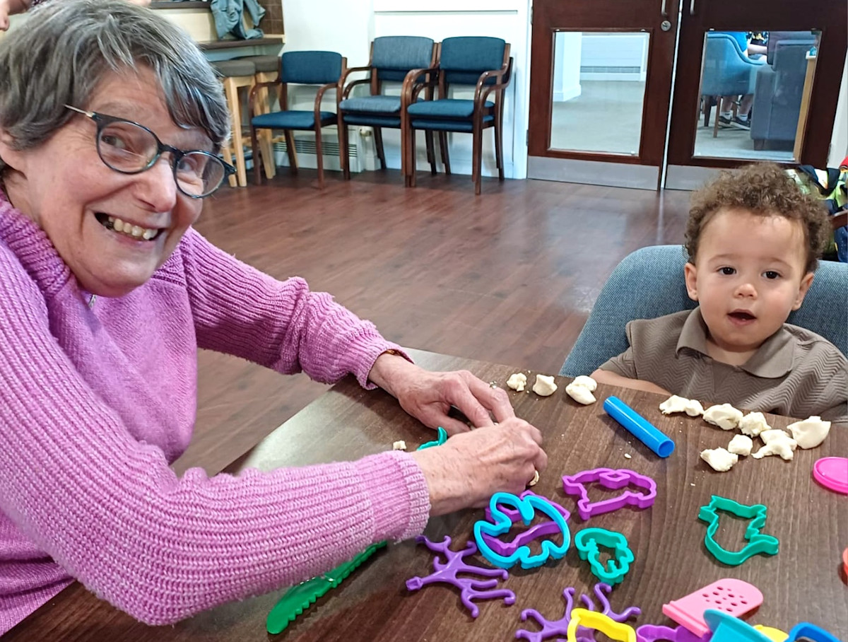 Pictured: Belong Macclesfield's Elaine Beckingham makes friends with young Omari. 