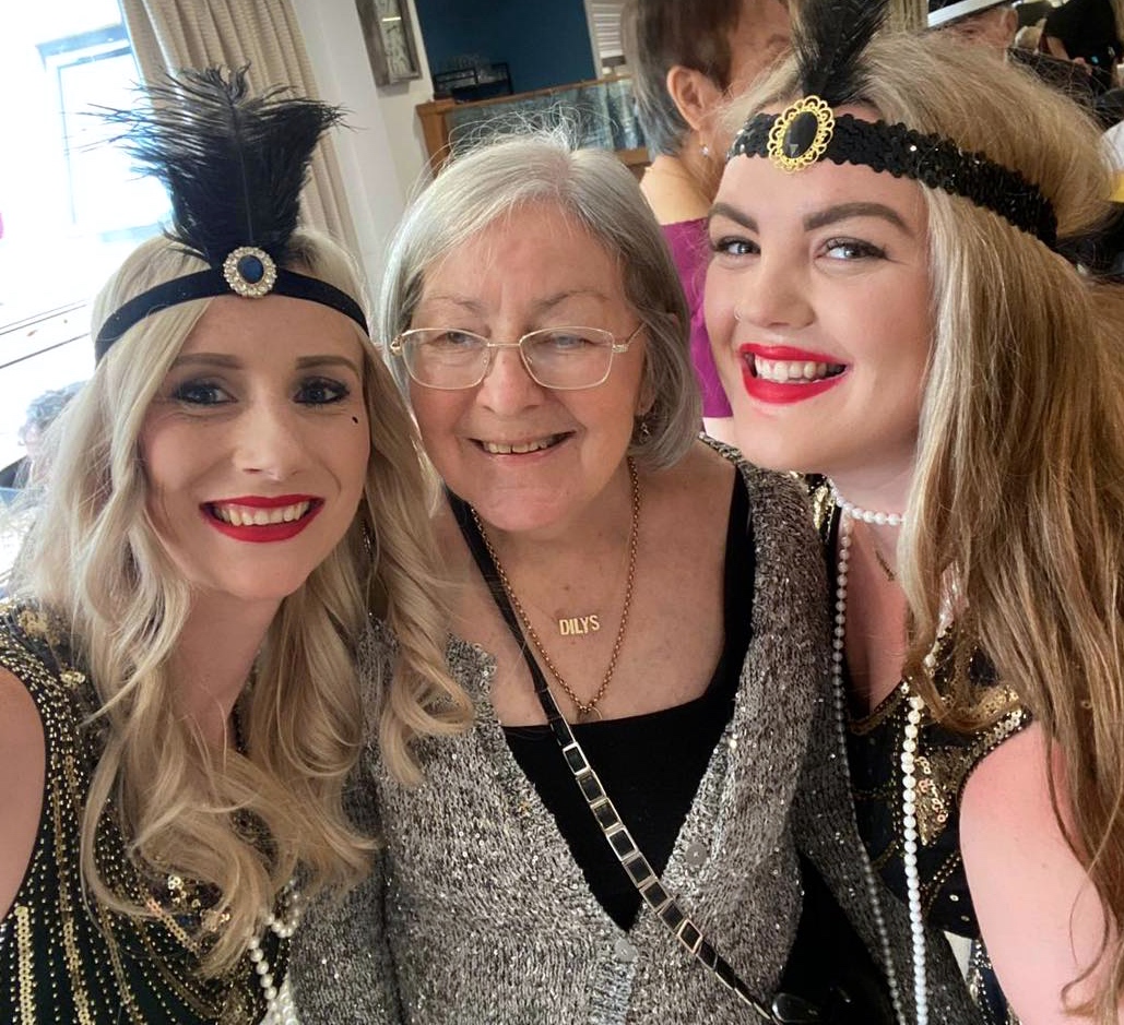 Belong Warrington resident Dilys Wolfendale parties with experience support workers Jade Shield (left) and Louise Kelly (right) 