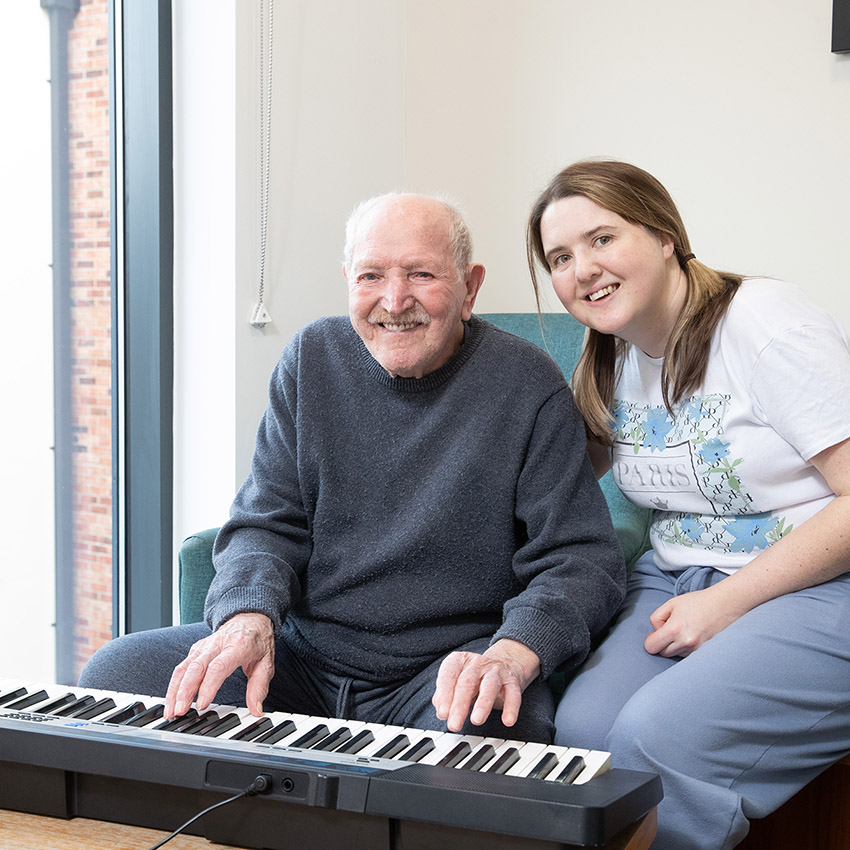 Belong Warrington Household resident playing the keyboard