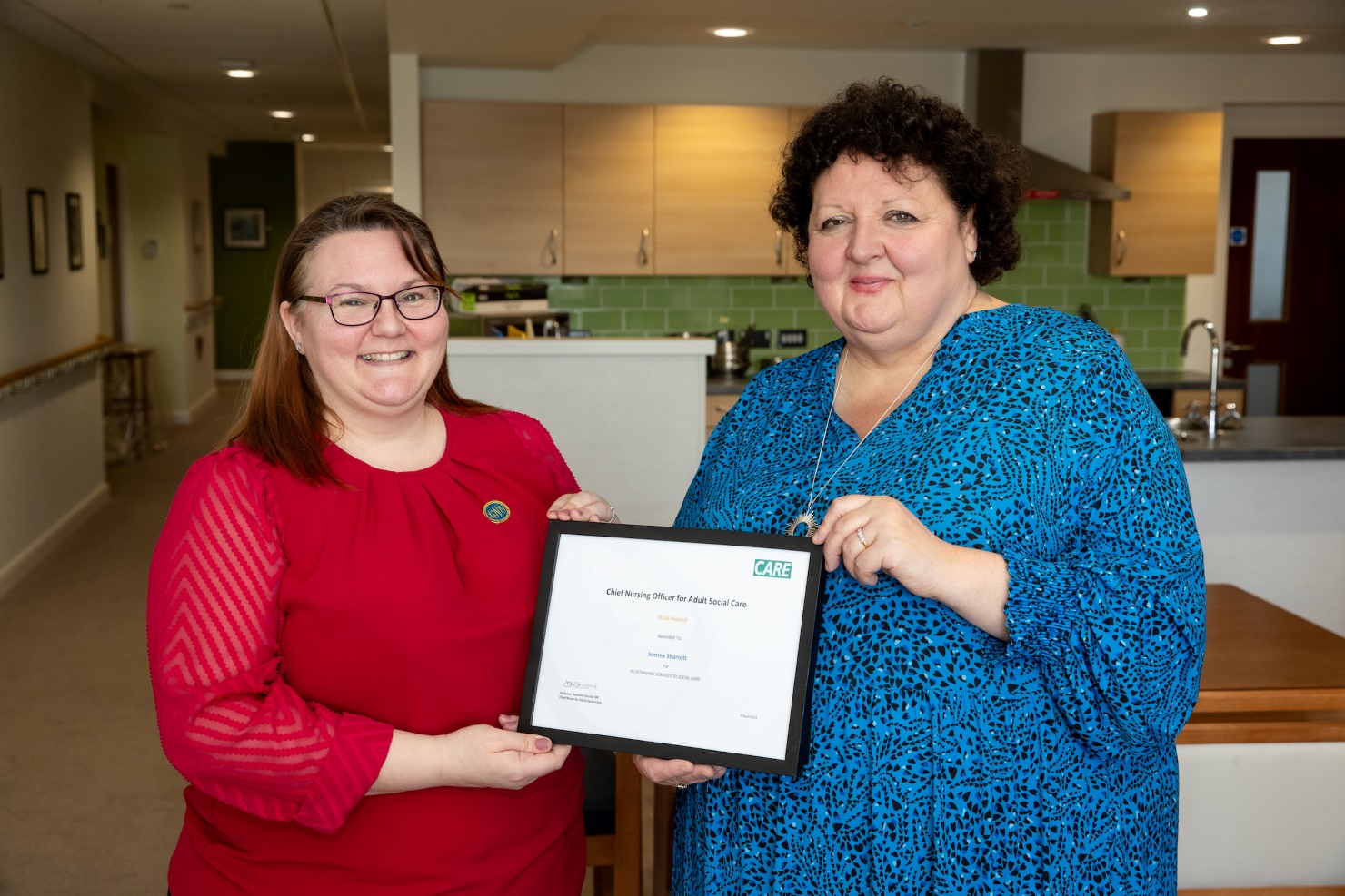 Pictured: Jemma Sharratt, village nurse manager at Belong Atherton, is presented with her award by Professor Deborah Sturdy CBE, chief nurse for adult social care in England. 
