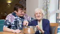 Belong Macclesfield Carer and resident cooking on household